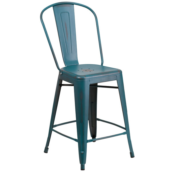 A blue metal restaurant counter height stool with a slat back and drain hole seat.