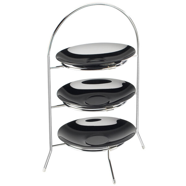 A black and silver metal three-tier display stand with black plates on it.