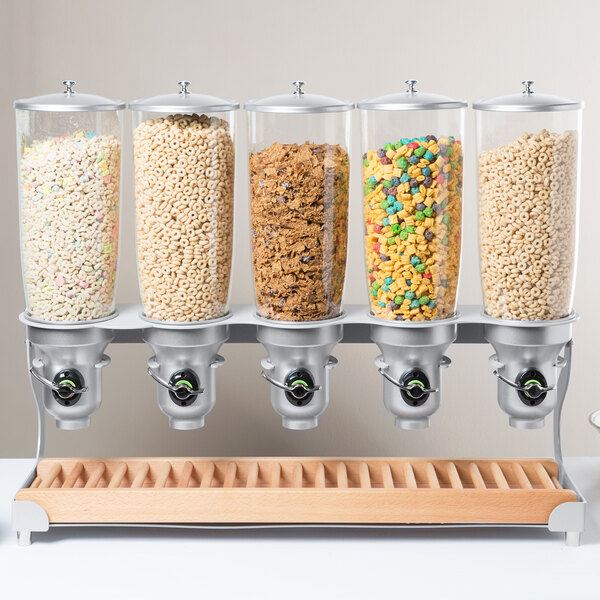 A Cal-Mil beechwood cereal dispenser holding colorful cereals.