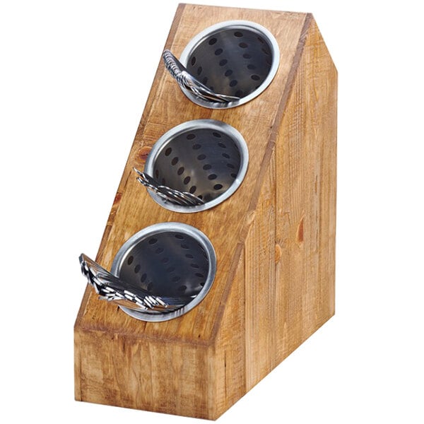 A wooden block with three metal bowls on top holding silverware.