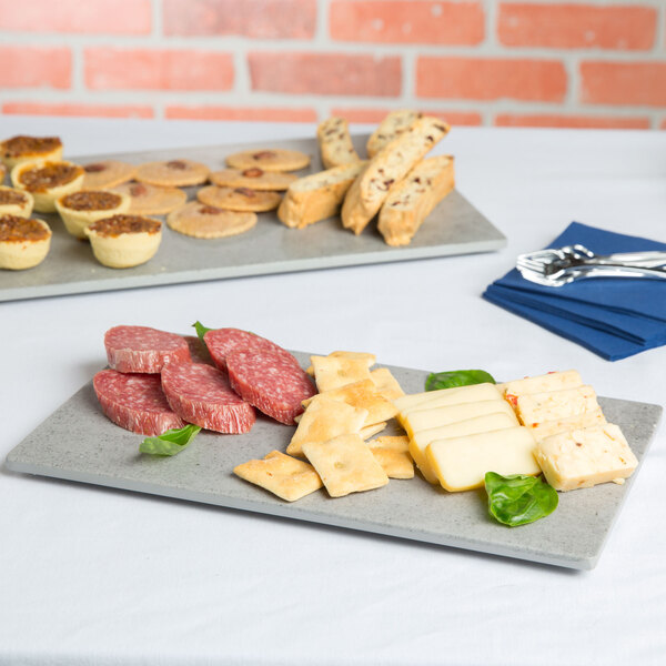 A Cal-Mil rectangular faux cement melamine serving platter with cheese, crackers and bread on it on a table.