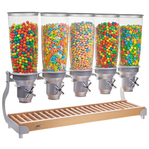 A group of Cal-Mil beechwood cereal dispensers filled with colorful candy.