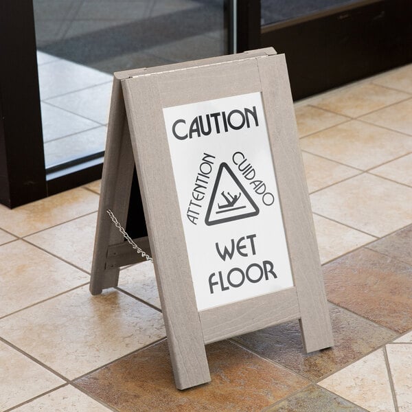 A Cal-Mil 2-sided wet floor sign on a tile floor.