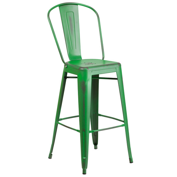 A green metal bar stool with backrest and seat with drain hole.