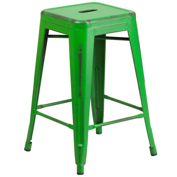 A Flash Furniture distressed green metal counter height stool with legs and a drain hole seat.