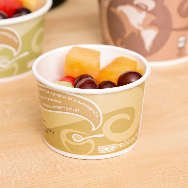 A cup of fruit and a cup of yogurt in a paper cup with a label.