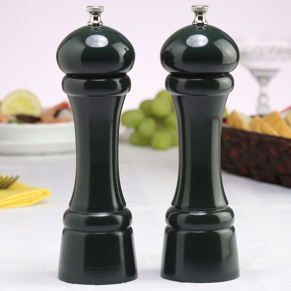 A Chef Specialties Autumn Hues forest green pepper mill and salt mill set on a table.