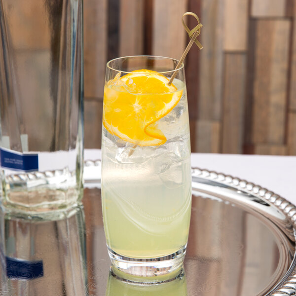 A Spiegelau Vino Grande Collins glass of lemonade with ice and a slice of lemon.