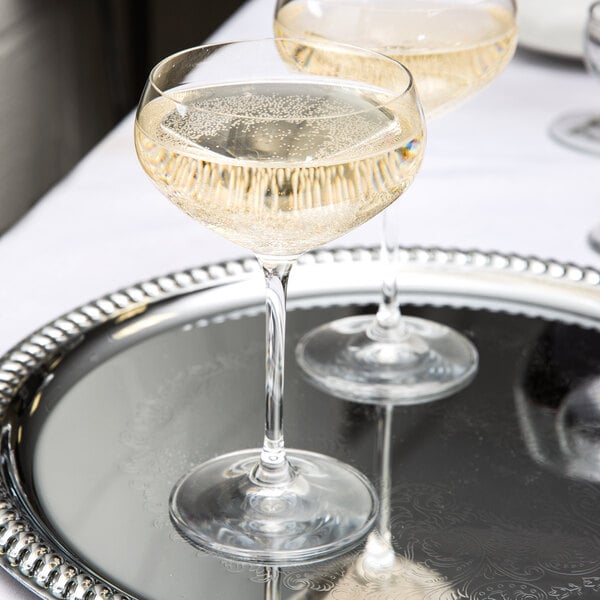 Two Spiegelau Vino Grande champagne saucers on a silver tray.