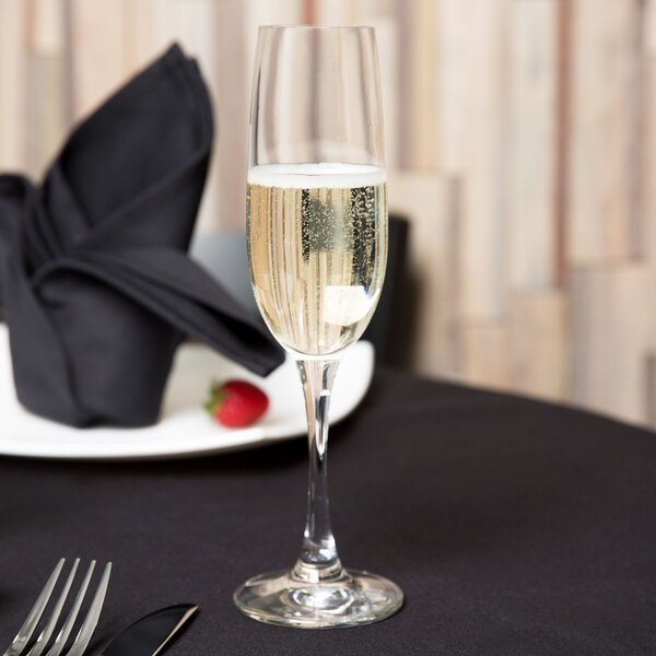 A Spiegelau Soiree flute of champagne on a table with a fork and knife.
