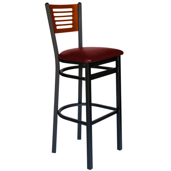 A BFM Seating black metal bar chair with a red vinyl seat and cherry wood back.