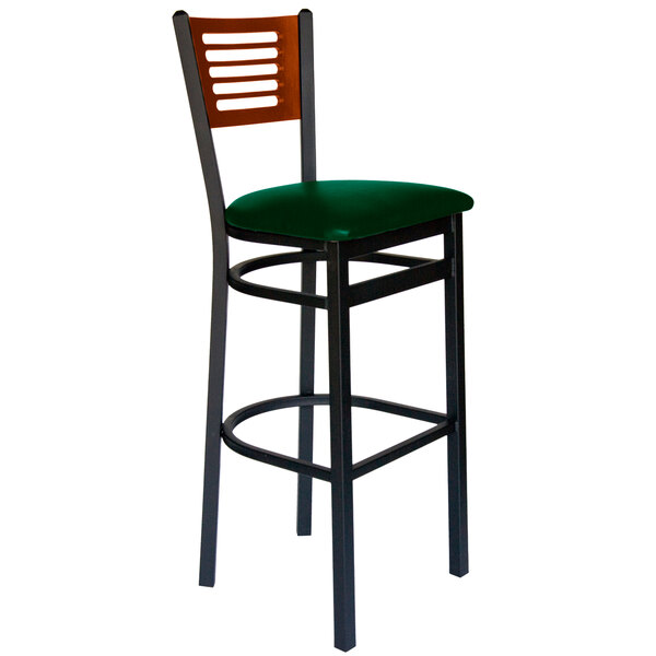 A BFM Seating black metal restaurant bar stool with a green vinyl seat.