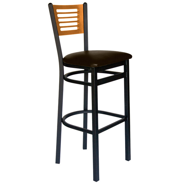 A BFM Seating black metal bar stool with a dark brown vinyl seat and natural wood back.