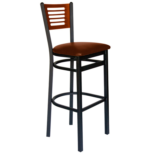 A BFM Seating black metal bar chair with a cherry wood back and light brown vinyl seat.