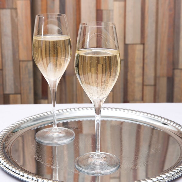 Two Spiegelau Authentis champagne flutes on a silver tray.