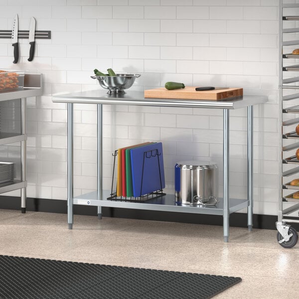 A Steelton stainless steel work table with undershelf holding different colored cutting boards.