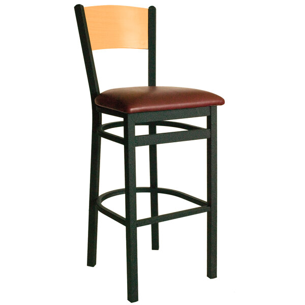 A BFM Seating black metal bar chair with a natural wood back and burgundy vinyl seat.