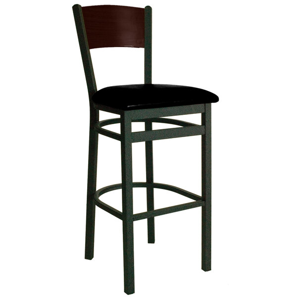 A BFM Seating black metal bar chair with a black vinyl seat and walnut finish wooden back.