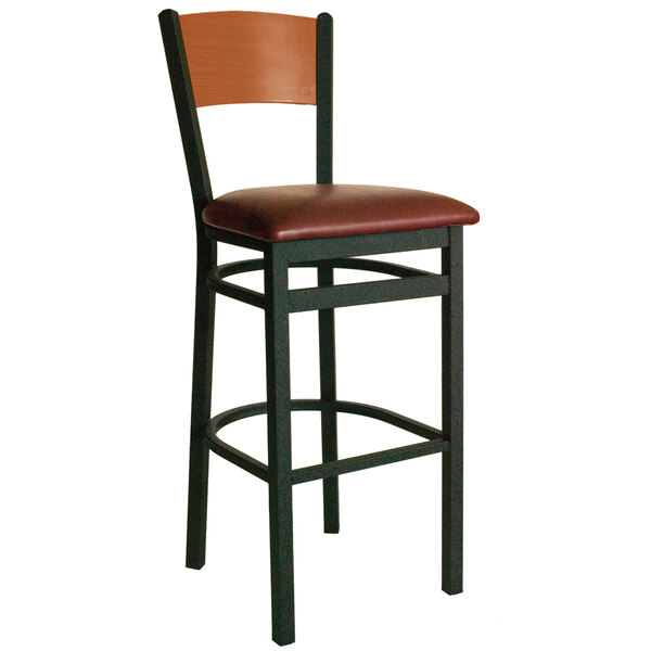 A BFM Seating black metal bar stool with a cherry wood back and burgundy seat.