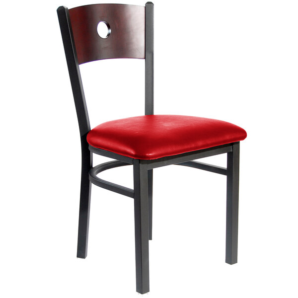 A BFM Seating black metal side chair with red vinyl seat and mahogany back.