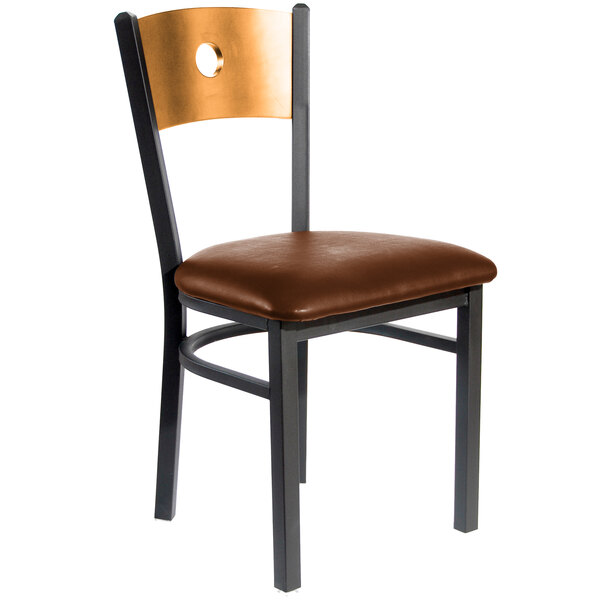 A BFM Seating black metal side chair with a natural wood back and light brown vinyl seat.