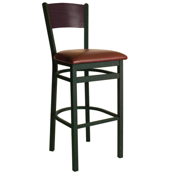 A BFM Seating black metal bar stool with a mahogany wood back and burgundy seat.