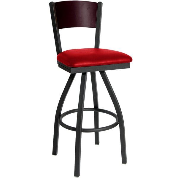 A black metal restaurant bar stool with mahogany wood accents and a red vinyl seat.