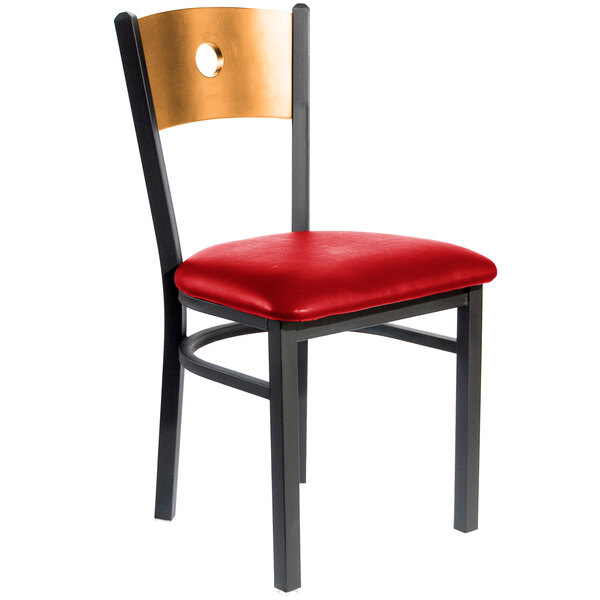 A BFM Seating black metal side chair with a natural wooden back and red vinyl seat.