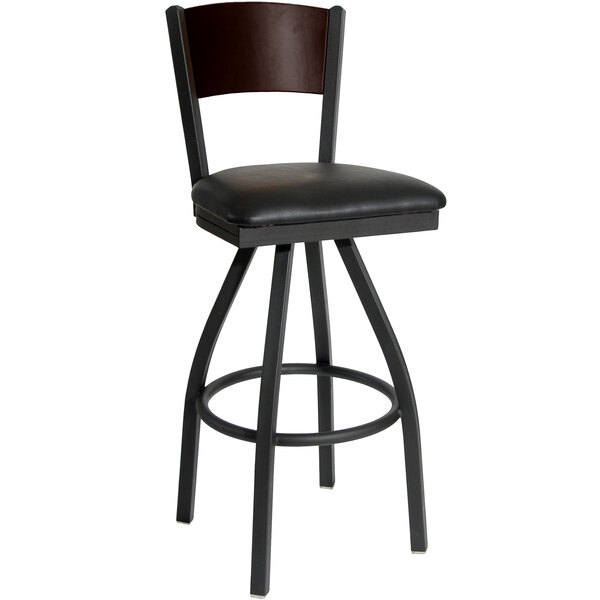 A BFM Seating Dale black metal bar stool with a black vinyl seat and walnut back.