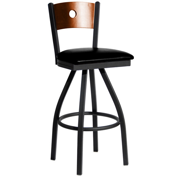 A black metal restaurant bar stool with a brown wooden back and black vinyl seat.