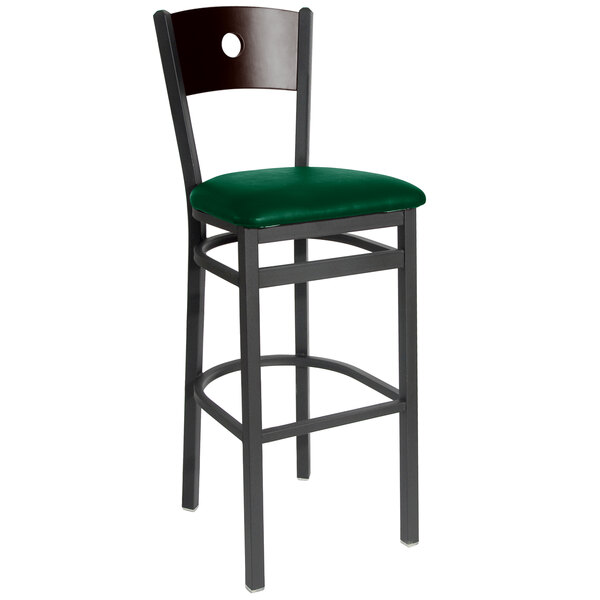 A BFM Seating black metal bar stool with a green vinyl seat.