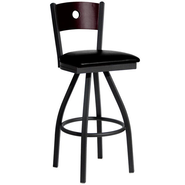 A BFM Seating black metal bar stool with a black vinyl seat and mahogany back.