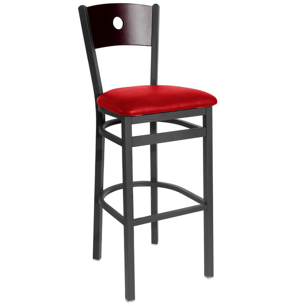 A BFM Seating black metal bar chair with a mahogany back and red vinyl seat.