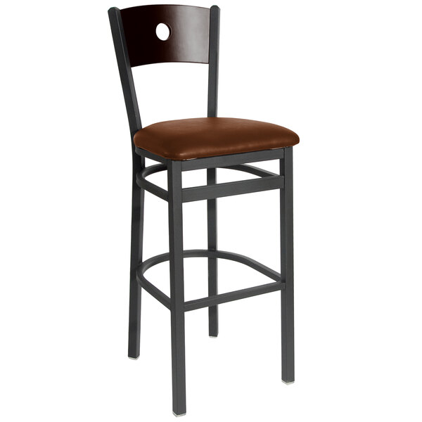 A BFM Seating black metal bar stool with a light brown vinyl cushion and walnut back.