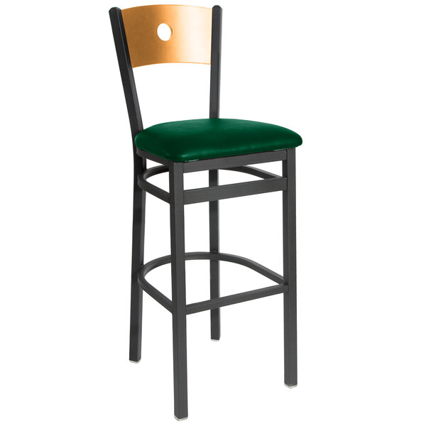 A BFM Seating black metal restaurant bar stool with a green vinyl seat and natural wood back.