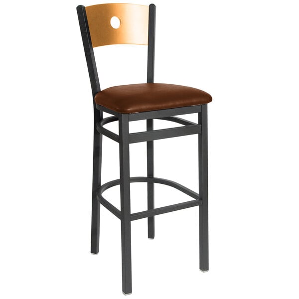 A BFM Seating black metal bar stool with a light brown cushioned seat and natural wooden back.