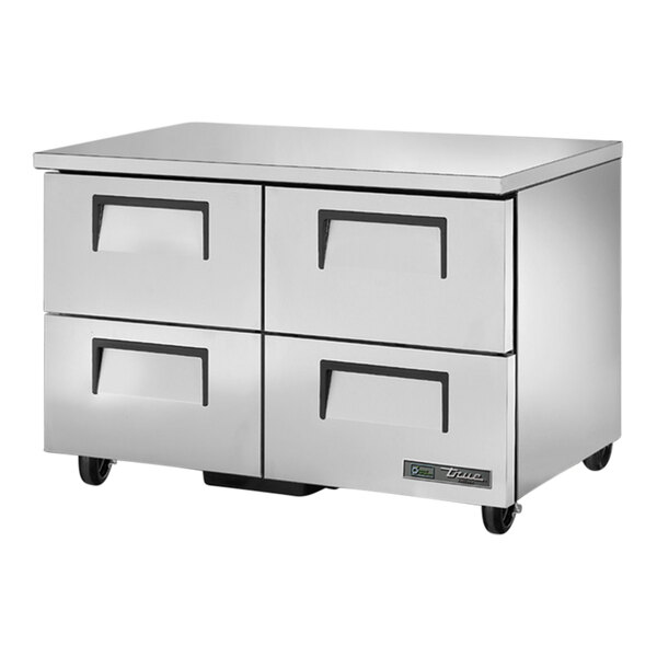 A stainless steel True undercounter freezer with four drawers.