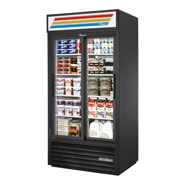 A black True refrigerated glass door merchandiser with shelves full of a variety of products.