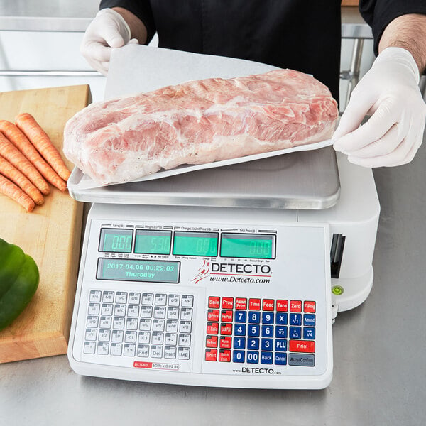 A person weighing a large piece of meat on a Cardinal Detecto legal for trade scale.