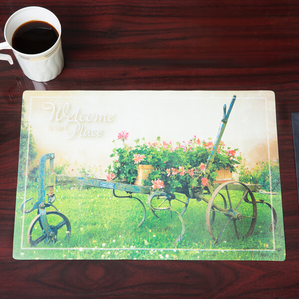 A Hoffmaster Welcome Paper Placemat on a table with a coffee cup and plate with a flower.