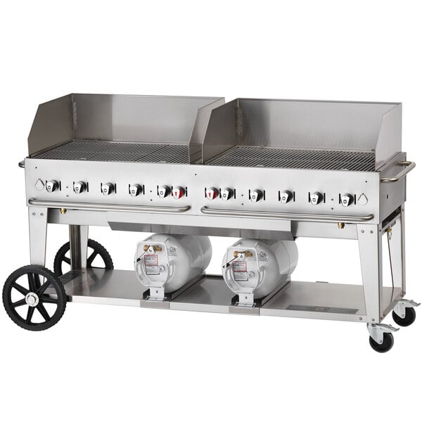 A large stainless steel Crown Verity outdoor grill with two horizontal propane tanks.