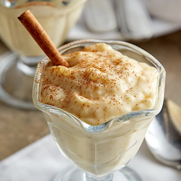 A glass cup with Lucky Leaf Tapioca Pudding and a cinnamon stick.