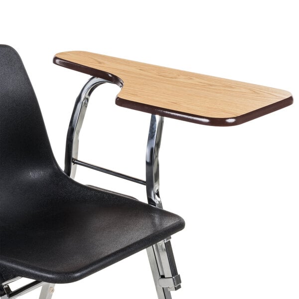 A black chair with a light oak tablet arm attached to the left side.