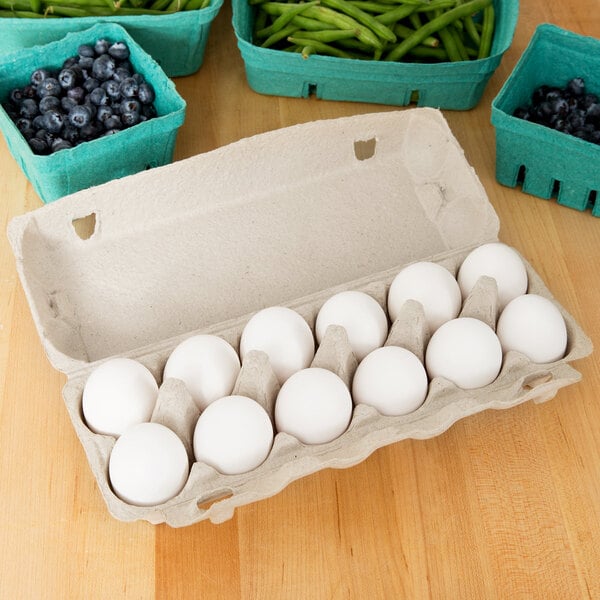 A Natural Pulp egg carton with eggs next to blueberries.