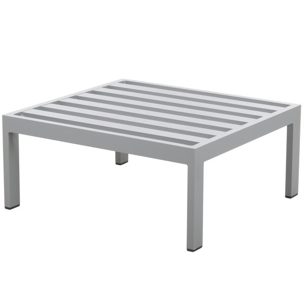 A soft gray aluminum square ottoman with slats.