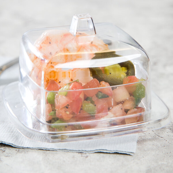 A Fineline clear plastic container with food on a counter.