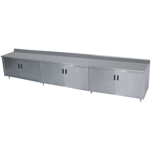 An Advance Tabco stainless steel work table with enclosed base and hinged doors.