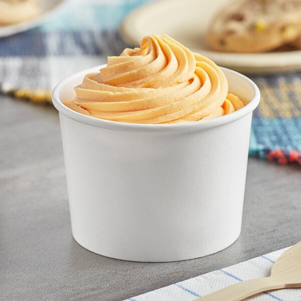 A white paper Choice frozen yogurt cup with orange ice cream inside.