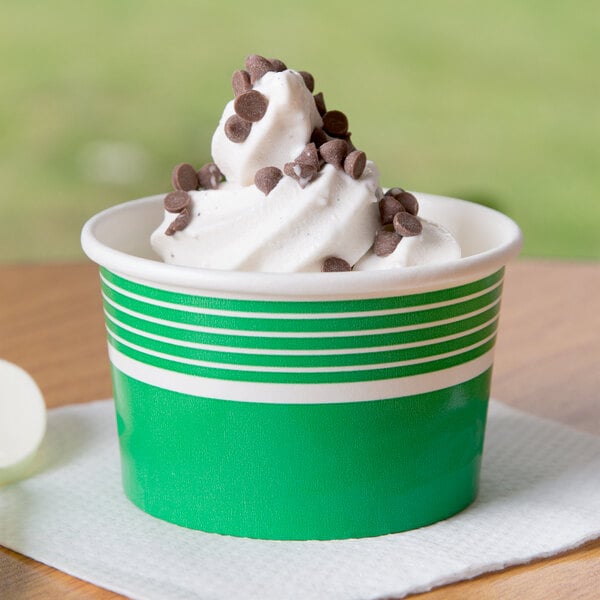 A green Choice paper cup filled with white ice cream and chocolate chips.