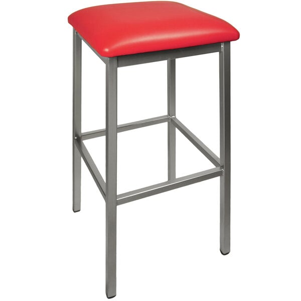 A BFM Seating Trent red vinyl restaurant bar stool with metal legs.